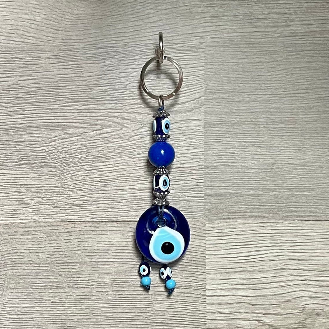 Handcrafted blue glass evil eye keychain with large round eye charm and small bead dangles