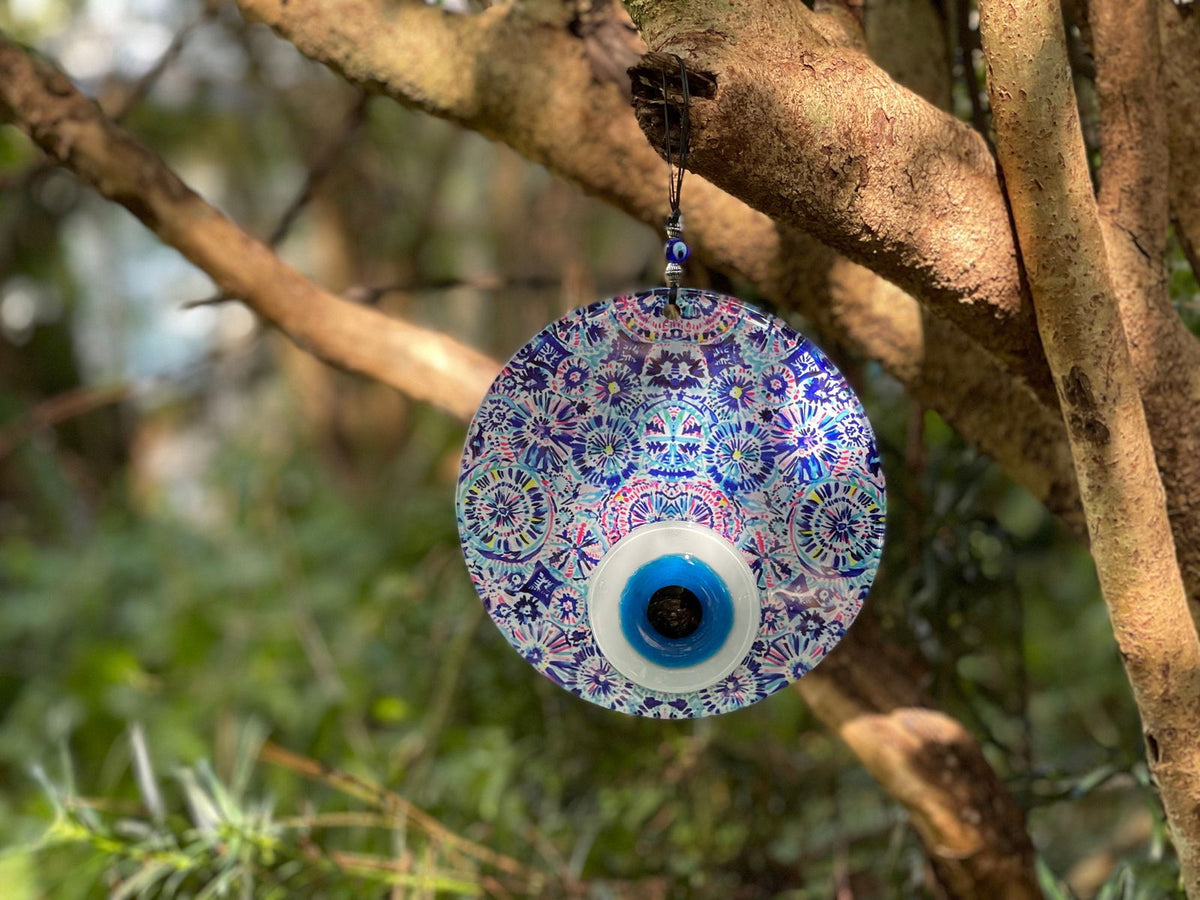 Evil eye wall hanging with blue and purple floral motif and dark blue center eye.