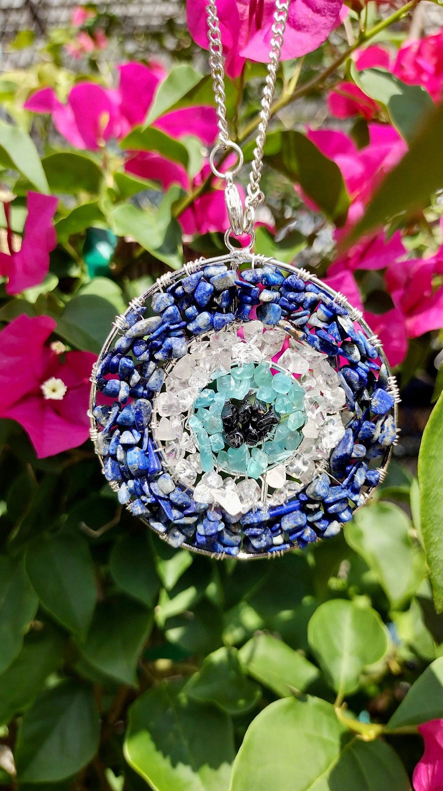 Round evil eye pendant with blue beaded border, aqua crystal center, silver chain