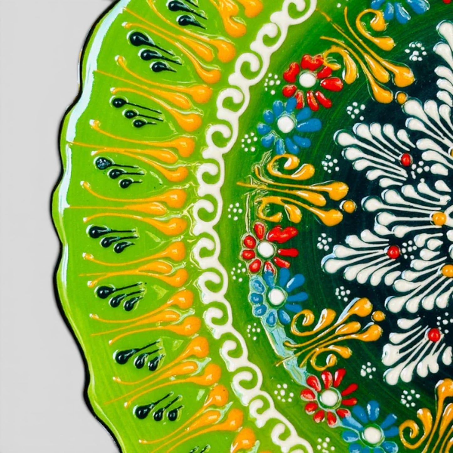 Hand-painted ceramic plate detail, bright green scalloped rim with floral tulip accents