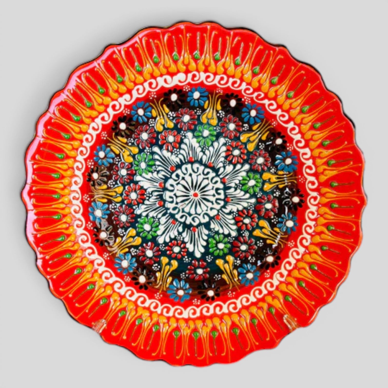 Bright orange ceramic decorative plate with floral dot tulip mandala pattern, scalloped rim