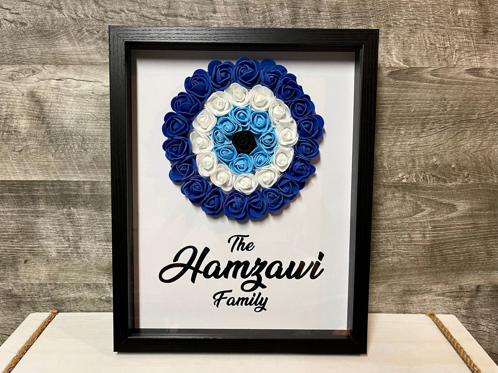 Personalized evil eye flower shadowbox with black frame, blue-and-white rose design, family name Hamzaoui