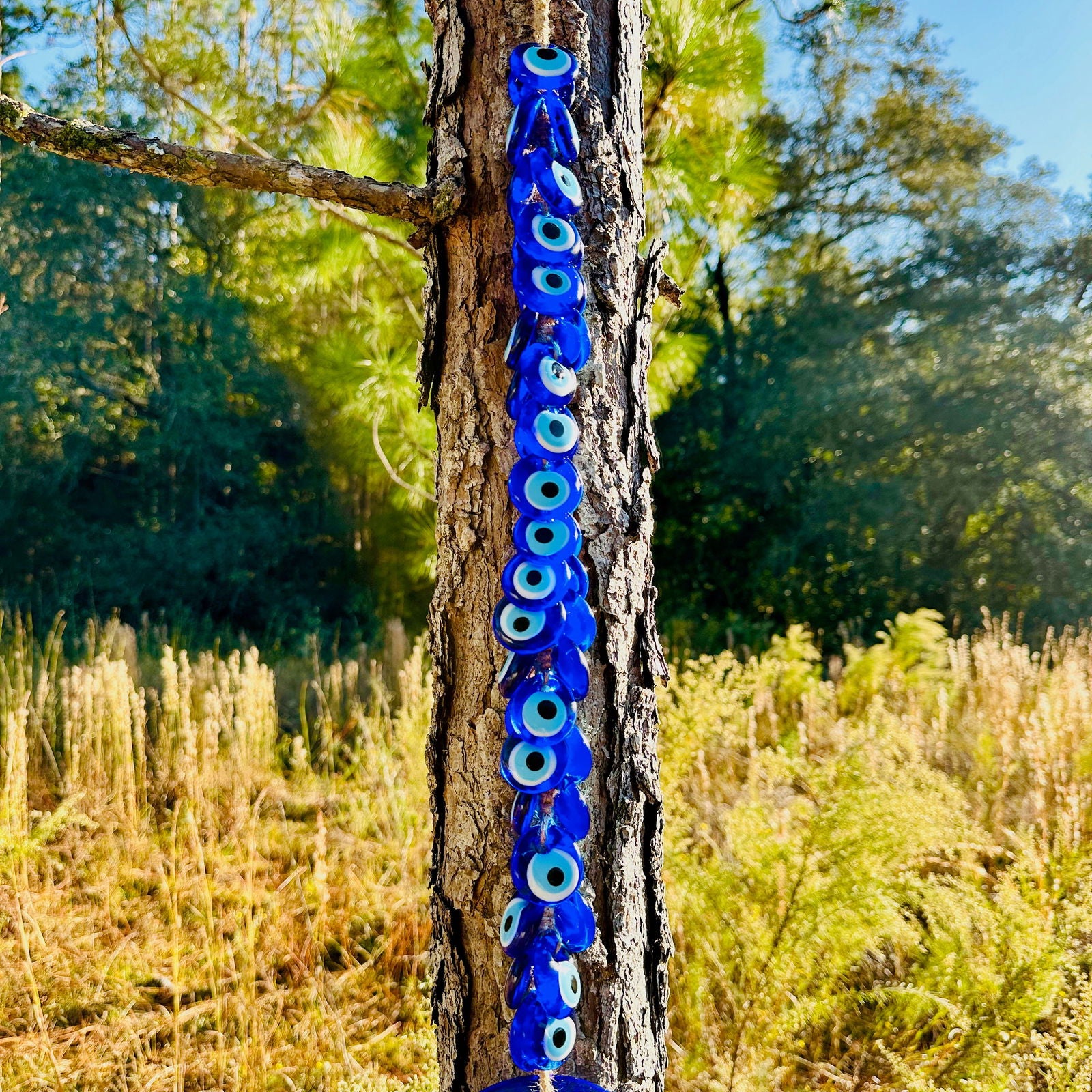Vertical row of blue evil eye beads hanging on a braided macrame cord