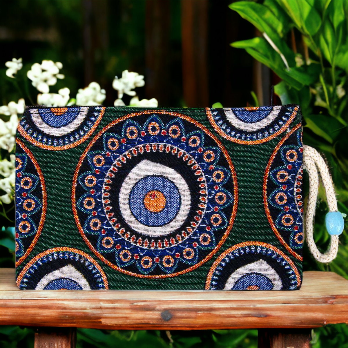 Green kilim clutch purse with evil eye mandala and blue-orange patterns, zipper top