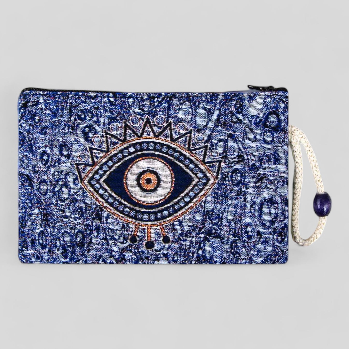Blue kilim clutch pouch with evil eye motif, zipper closure, and hanging tassel.
