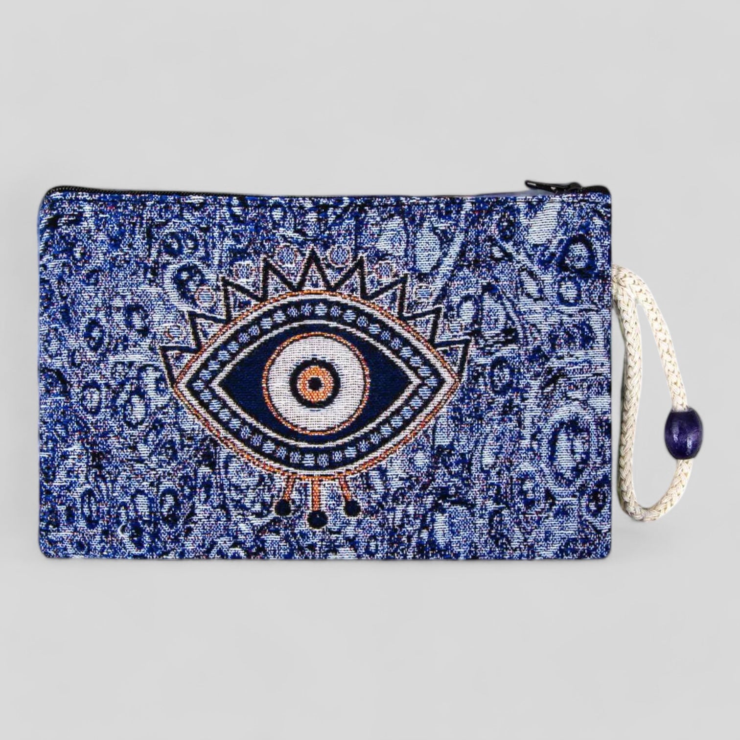 Blue kilim clutch pouch with evil eye motif, zipper closure, and hanging tassel.