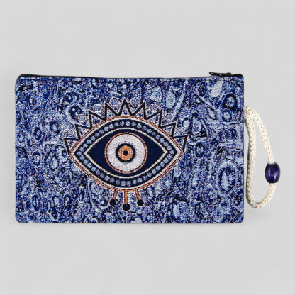 Blue kilim clutch pouch with evil eye motif, zipper closure, and hanging tassel.