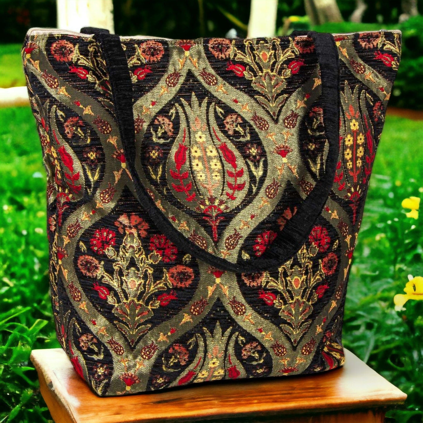 Black kilim-pattern tote purse with red and gold floral print and black handles