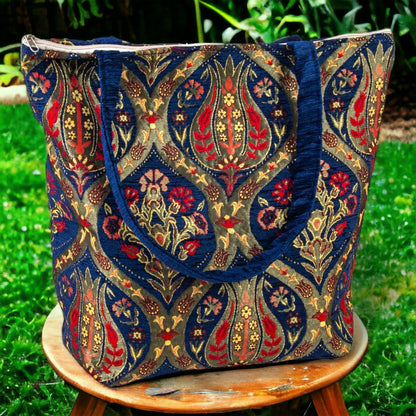Blue kilim fabric tote bag with ornate gold and red pattern and side handles