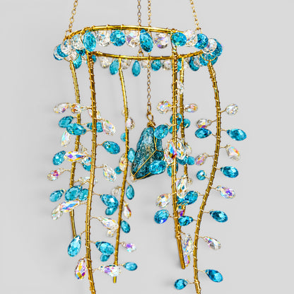 Gold hanging suncatcher with long bead strands and blue jellyfish center