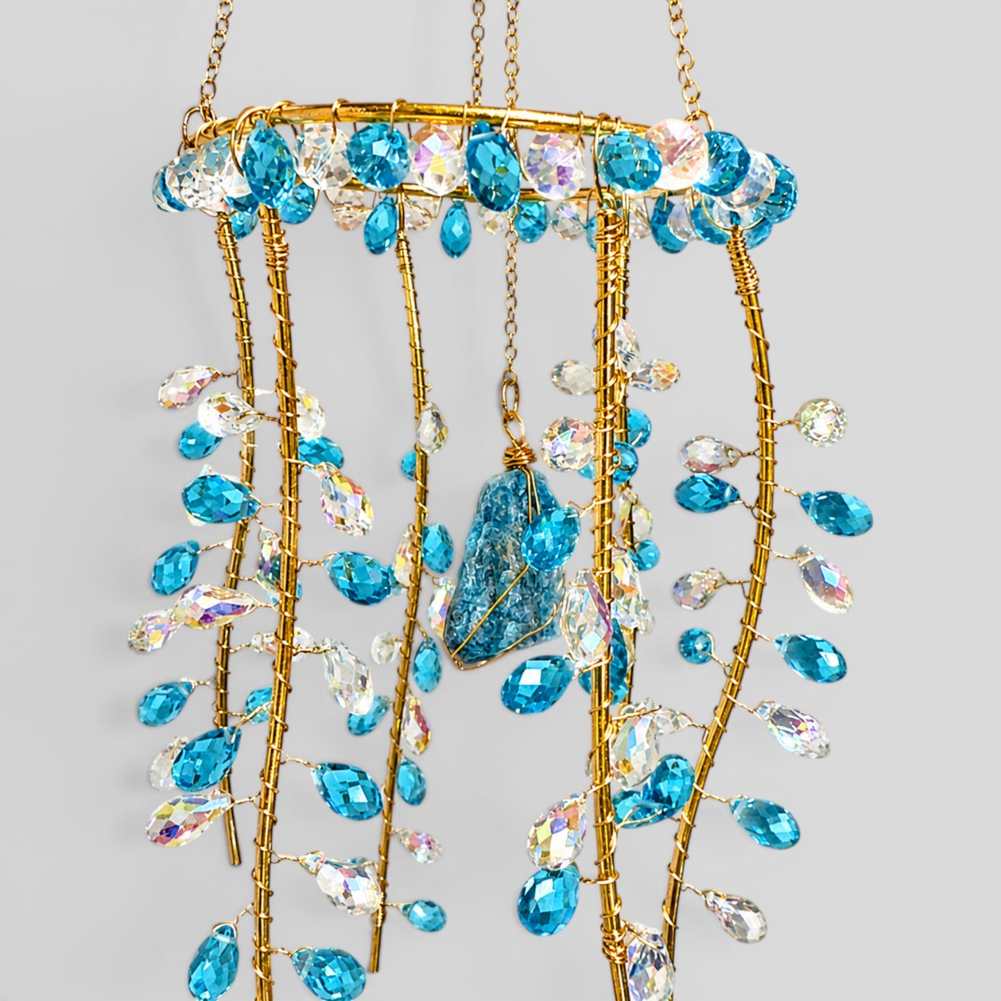 Gold hanging suncatcher with blue and clear bead drops, jellyfish-shaped centerpiece