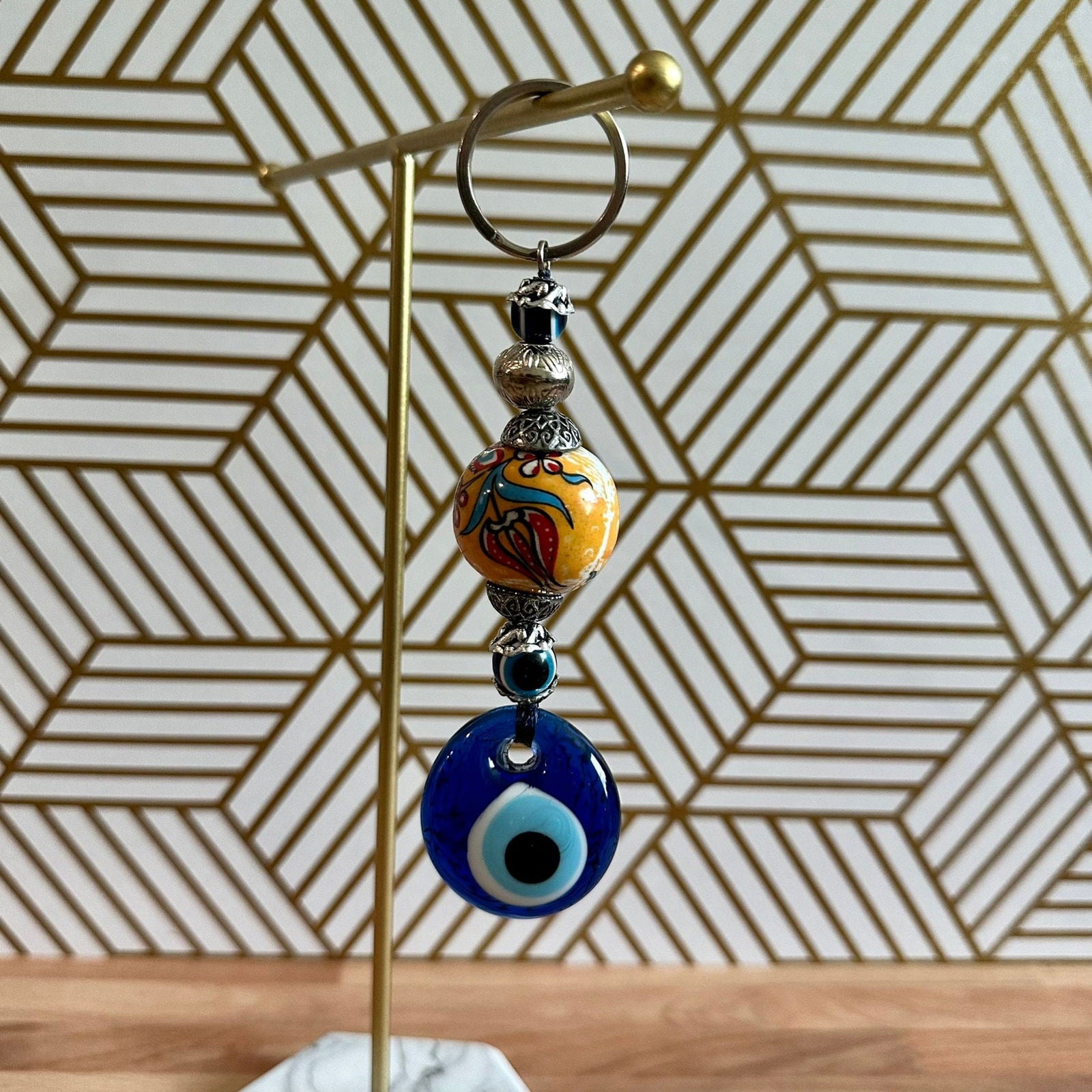 Evil eye keychain with gold ring and stacked blue and orange evil-eye charms