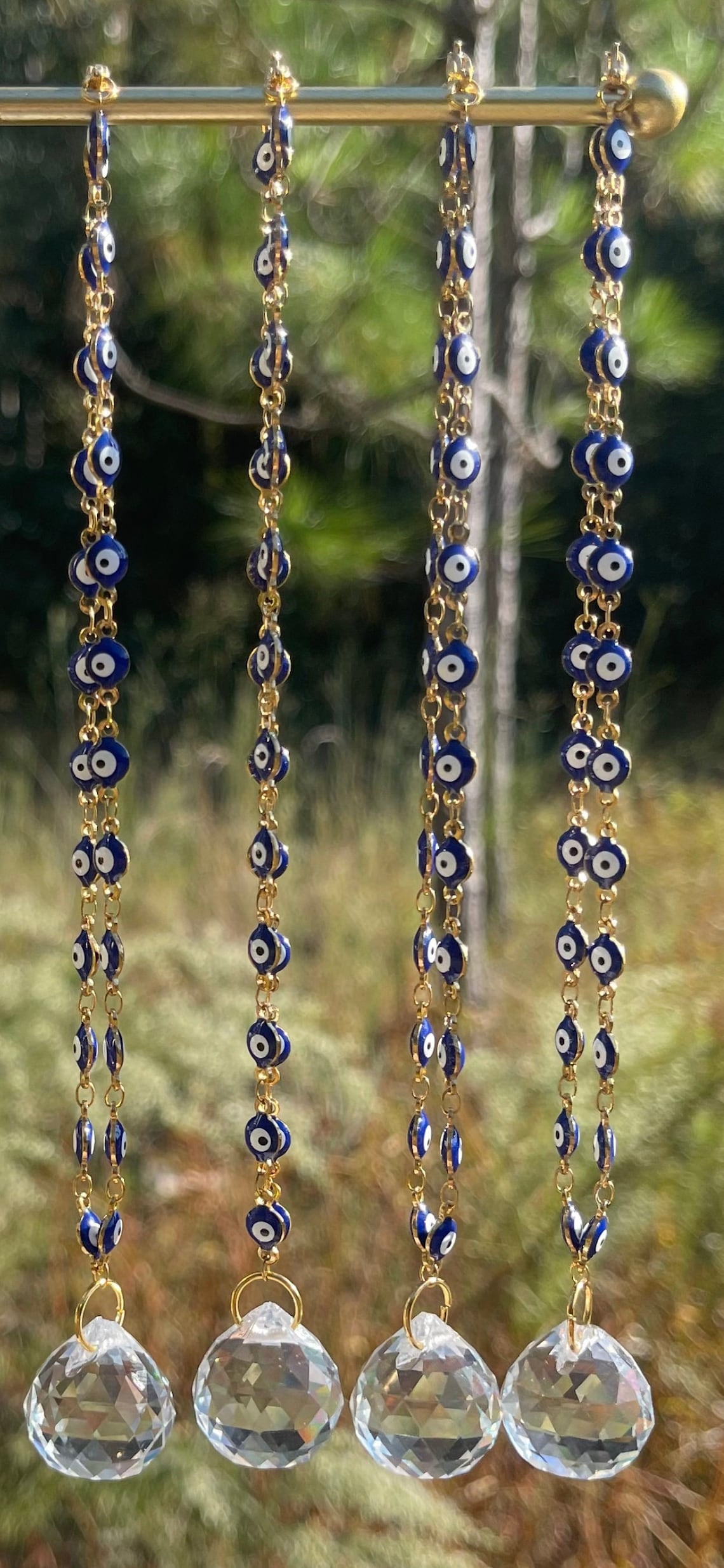 Evil eye rearview mirror charm with gold chain strands, blue beads, and clear crystal discs
