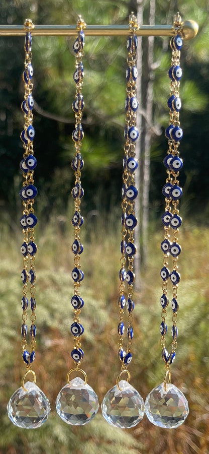 Evil eye rearview mirror charm with gold chain strands, blue beads, and clear crystal discs
