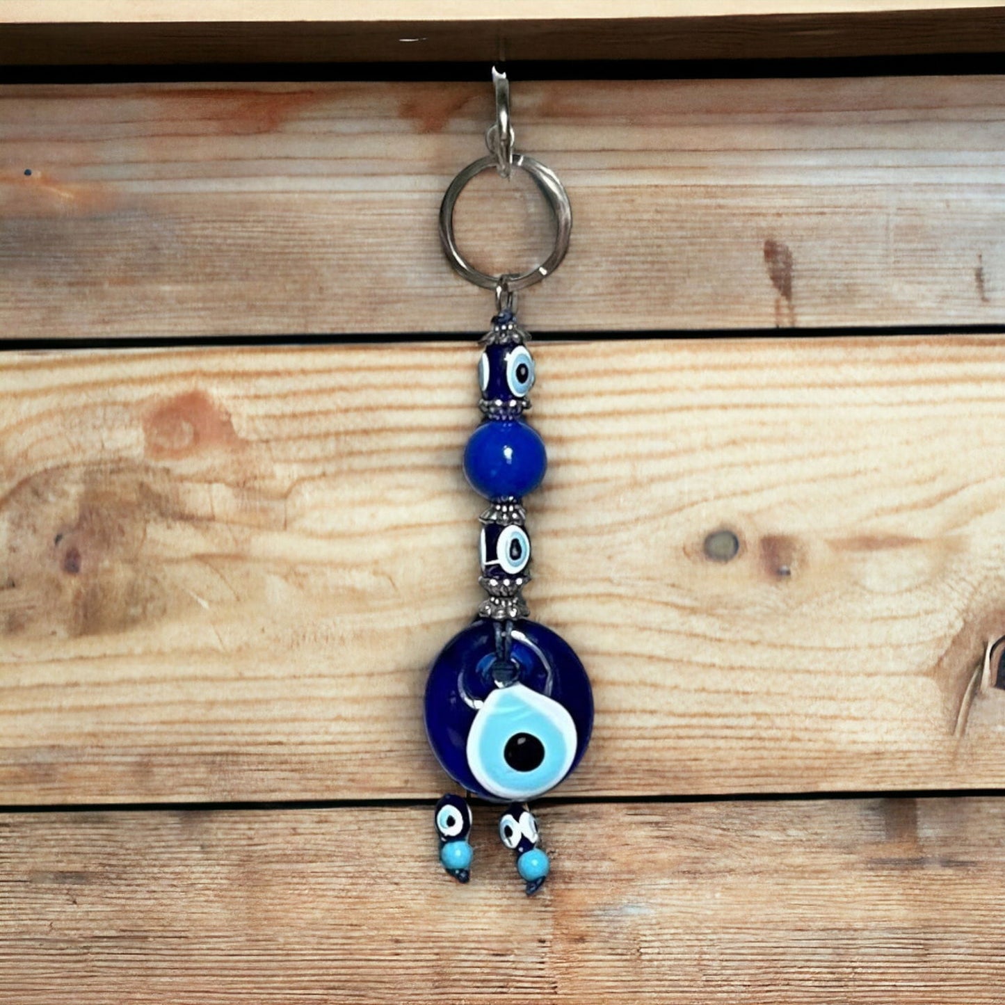 Evil eye bead keychain with blue glass charm and metal loop, hanging charms