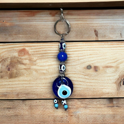 Evil eye bead keychain with blue glass charm and metal loop, hanging charms