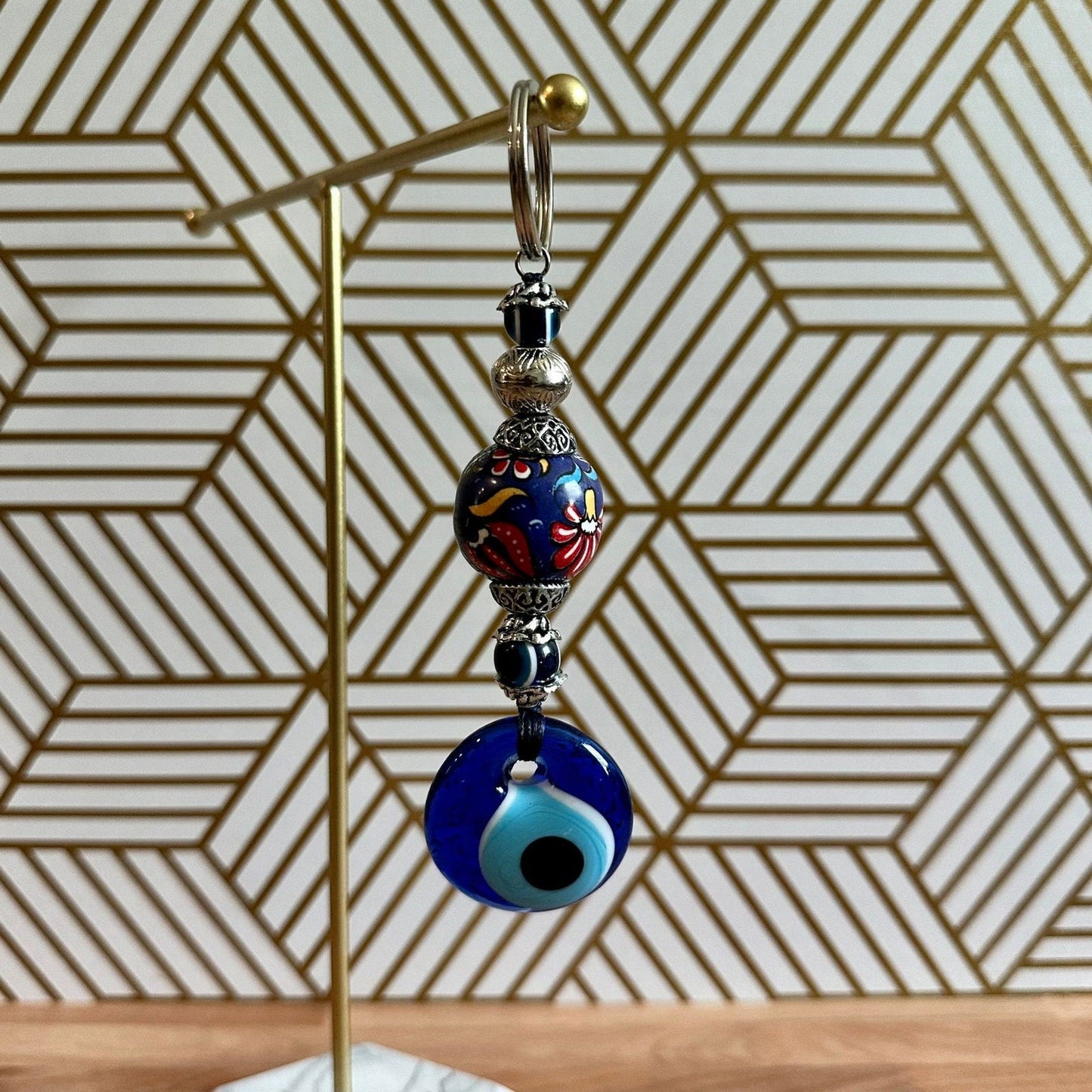 Evil-eye ceramic keychain with blue eye bead and hand-painted floral pendant