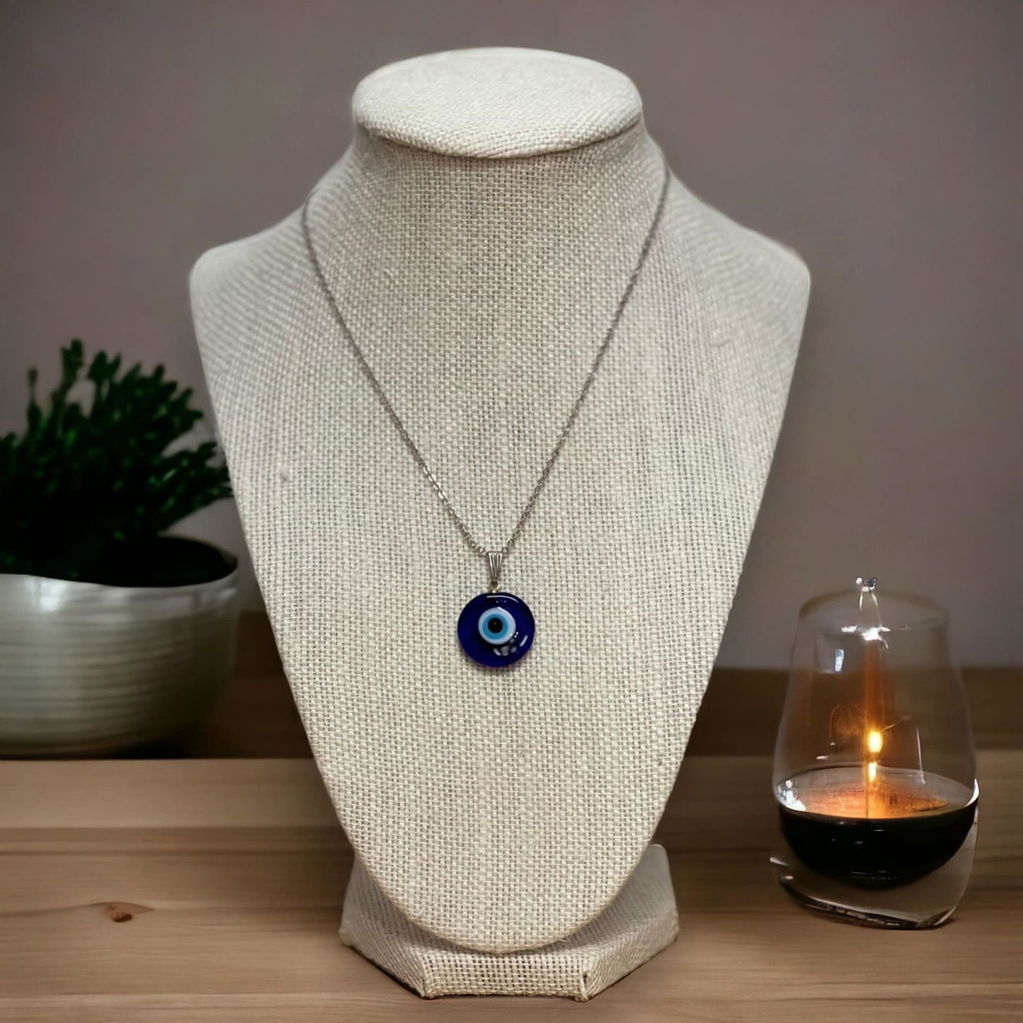 Round blue evil-eye charm pendant necklace on a thin silver chain