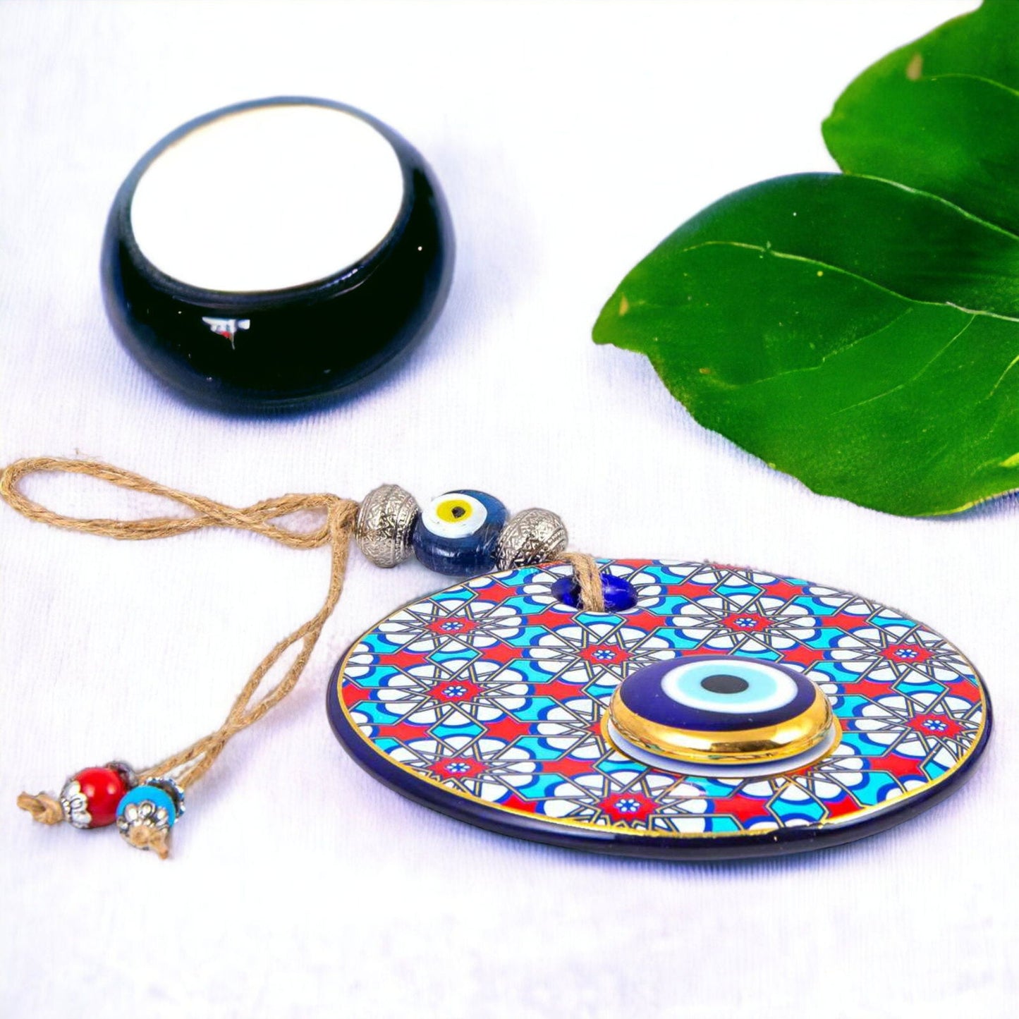 Evil eye wall hanging with blue-and-red mosaic circular pendant and gold eye bead, cord