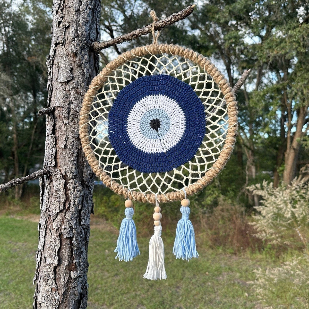 Round macrame evil eye wall hanging with navy/white center and hanging tassels