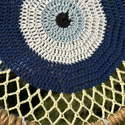 Navy and white crocheted evil eye wall hanging with textured circular stitches