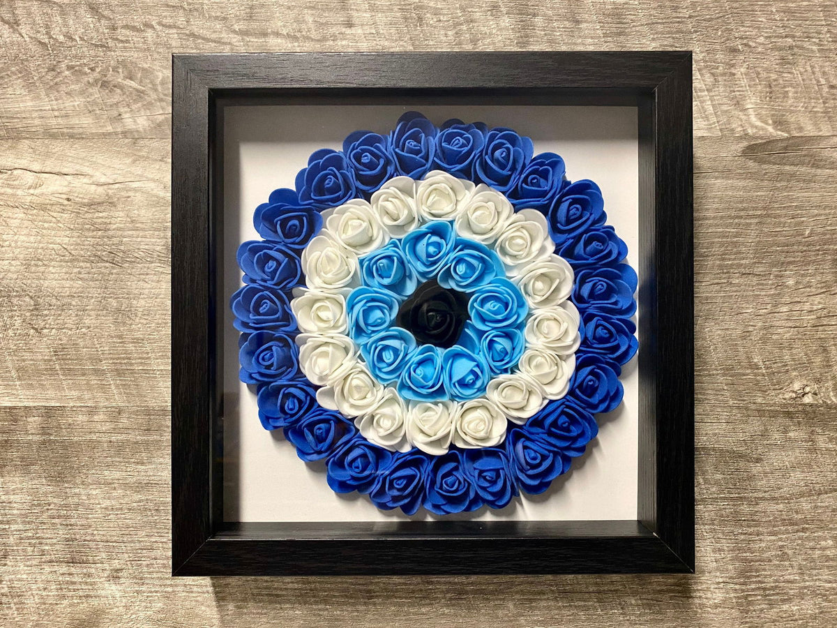 Black framed evil eye shadowbox with blue outer roses and white inner roses