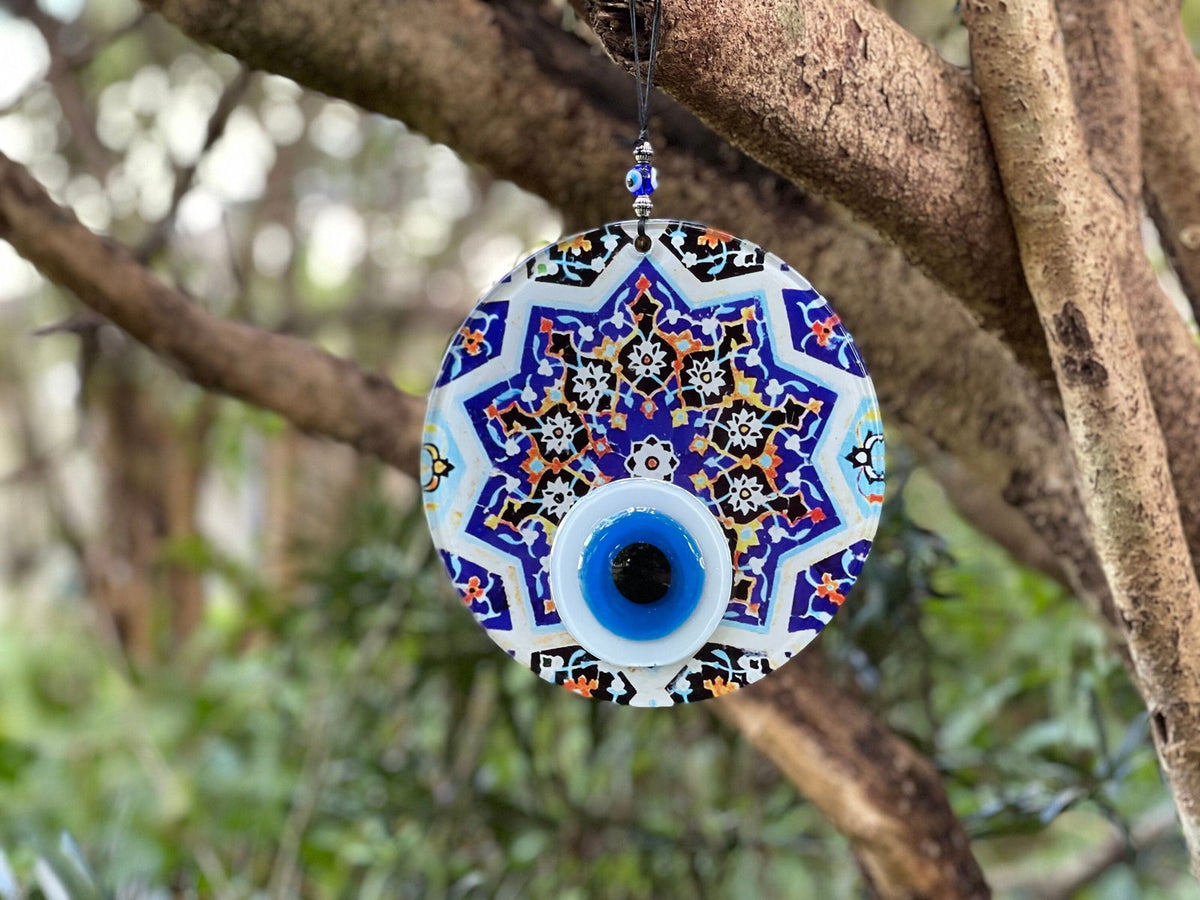 Evil eye wall hanging with blue geometric starburst pattern and dark blue eye.