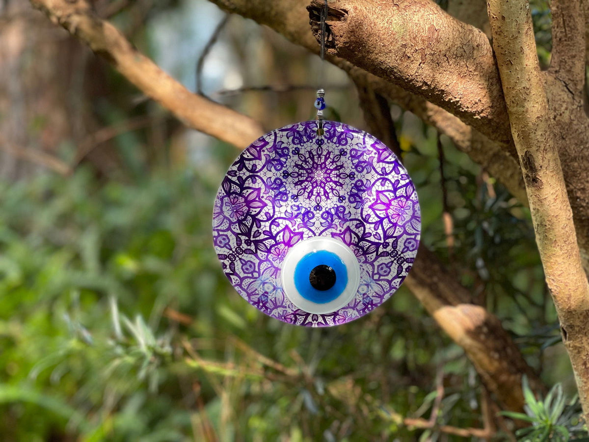 Evil eye wall hanging with purple floral pattern and dark blue center eye.