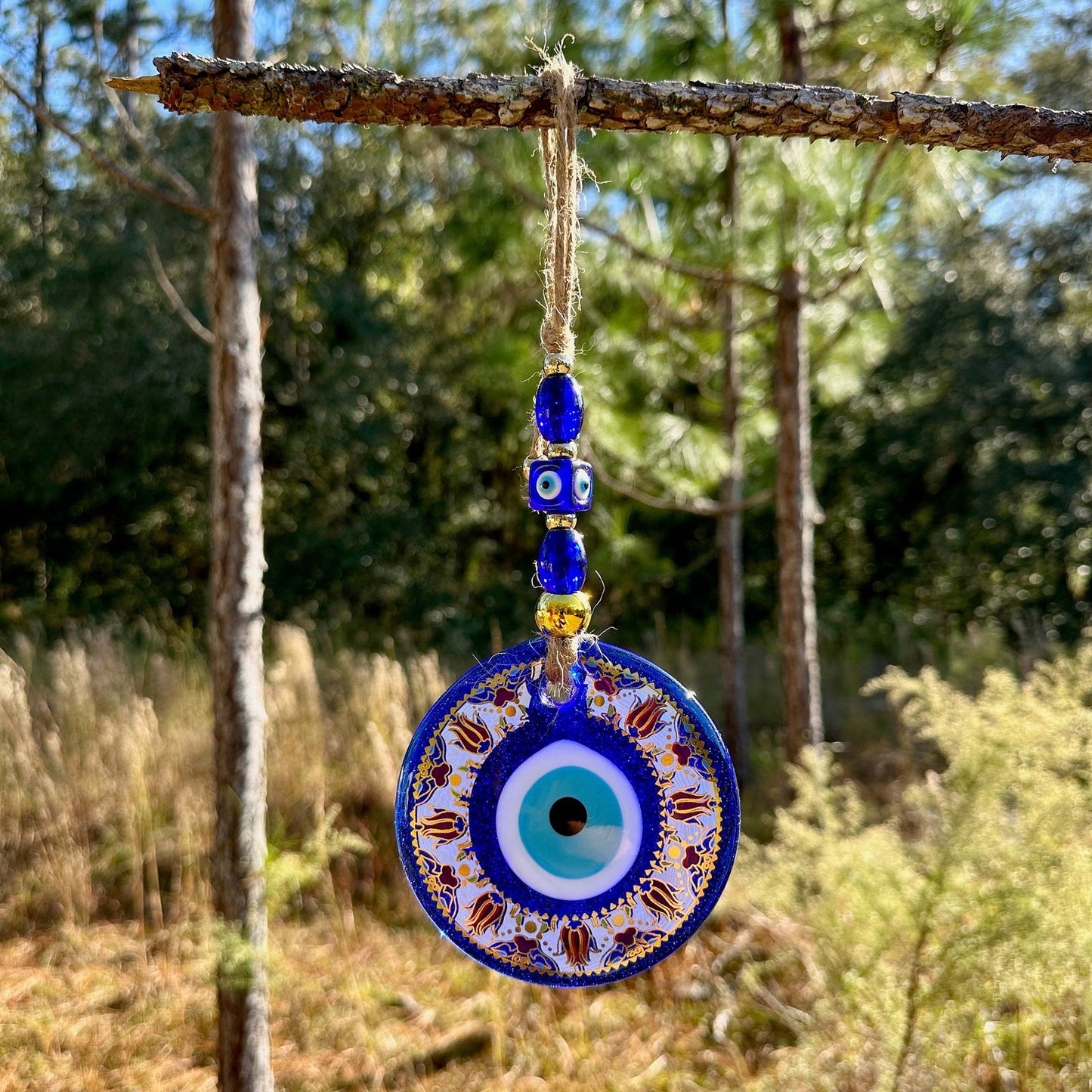 Blue evil eye wall hanging with round mandala disc and gold-trim bead chain