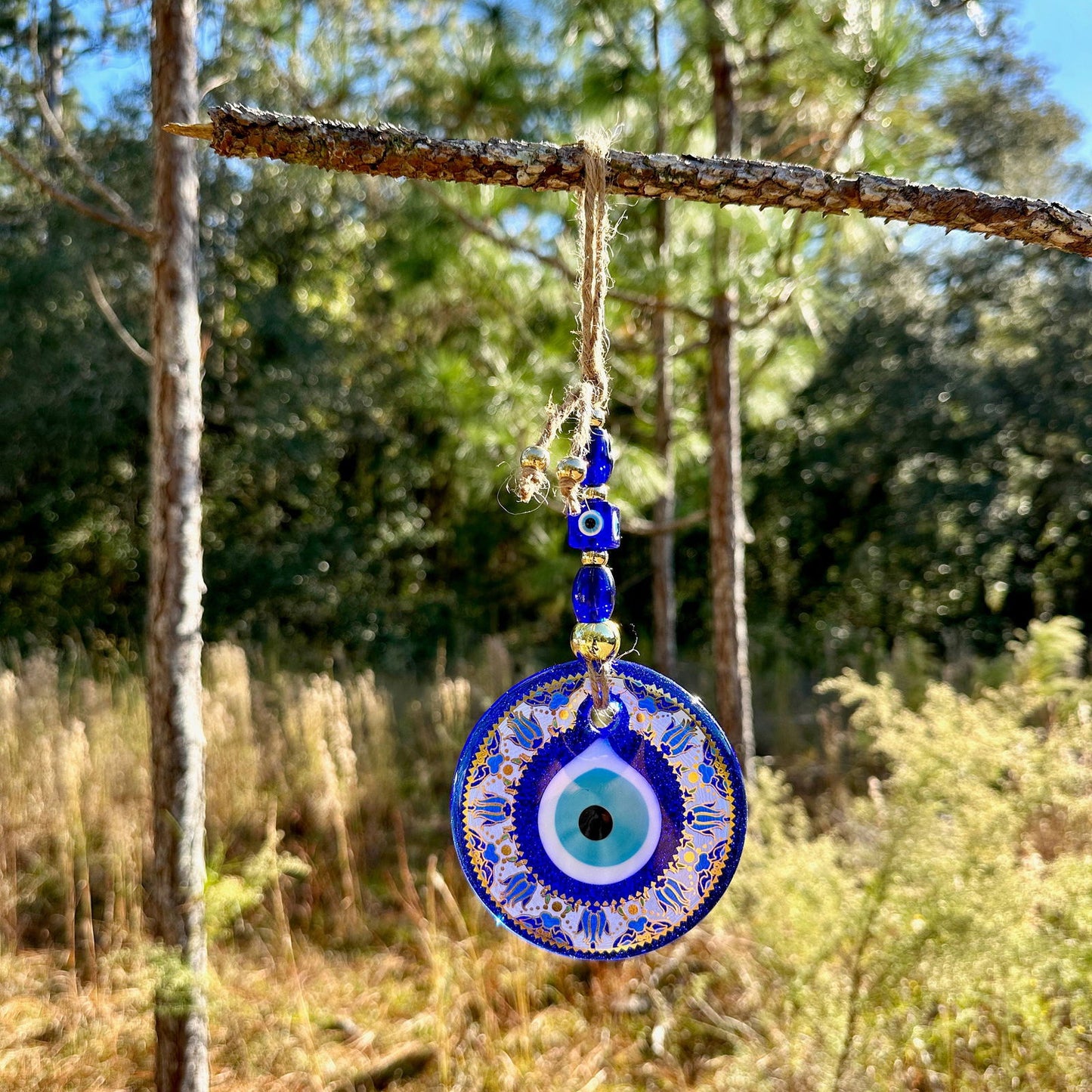 Blue evil eye wall hanging with single round mandala charm and gold-trim beads