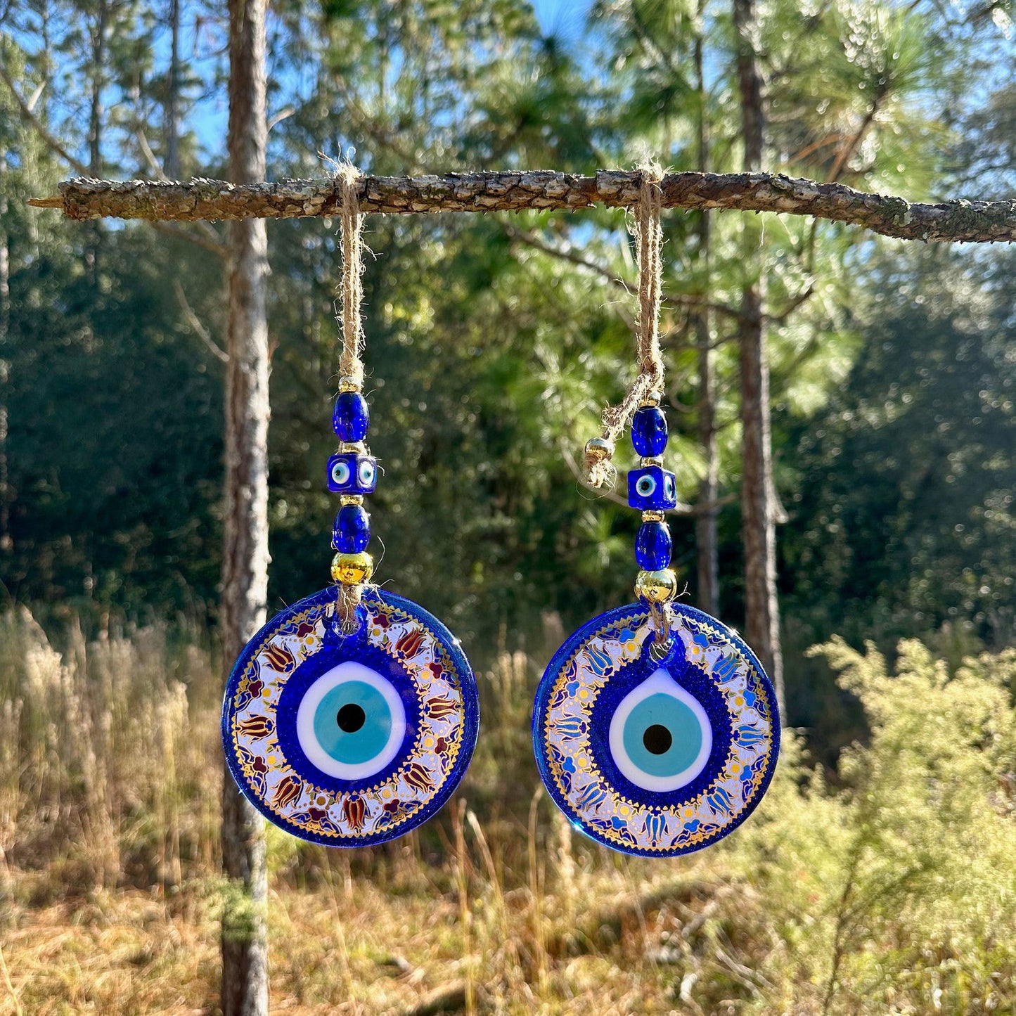 Blue evil eye wall hanging with round mandala charm and gold-trim beads, two discs