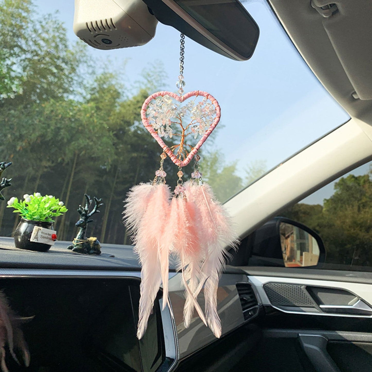 Pink heart dreamcatcher with feather fringe and bead details hanging from a mirror hook