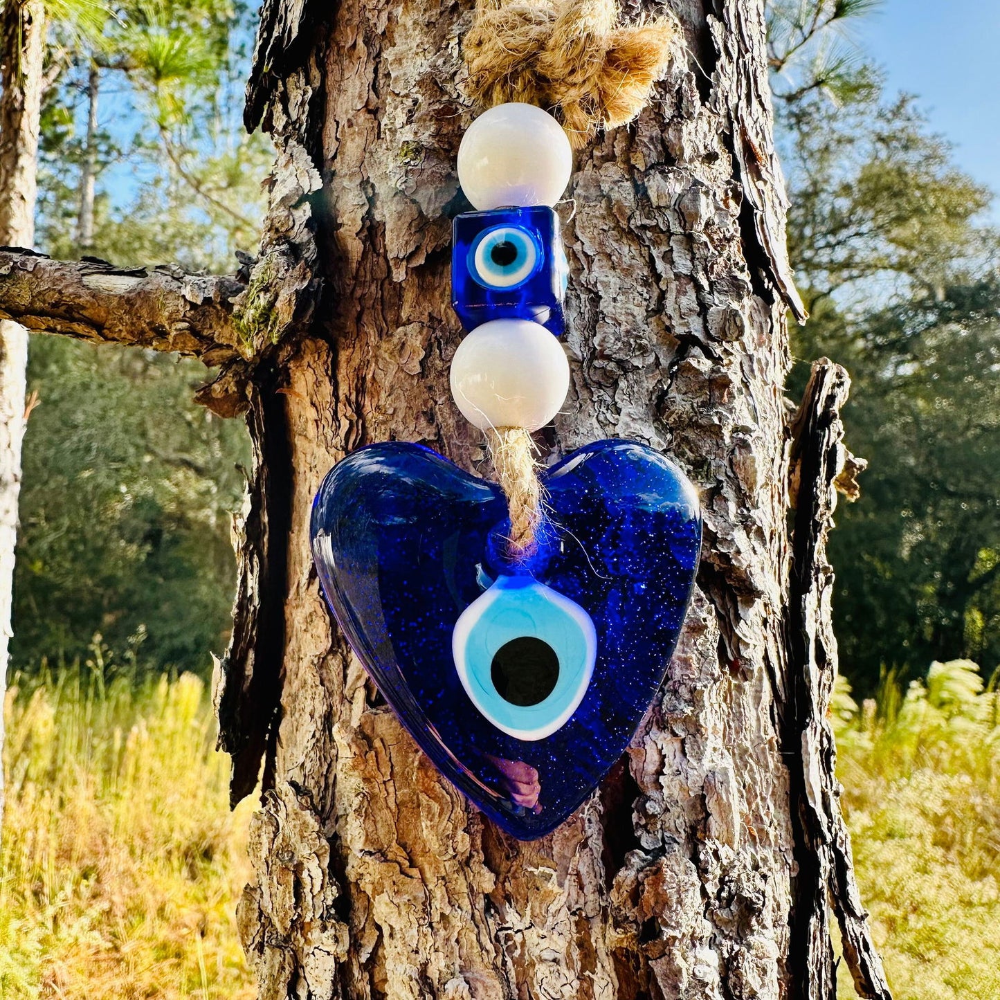 Blue heart glass evil eye pendant with white beads and eye disk charm on rope