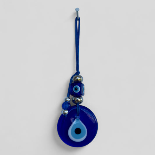 Blue evil eye wall hanging with round blue eye bead and metallic charm accents