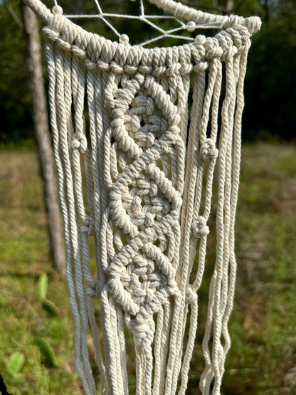 Cream macrame dream catcher web with thick twisted strands and hanging fringe