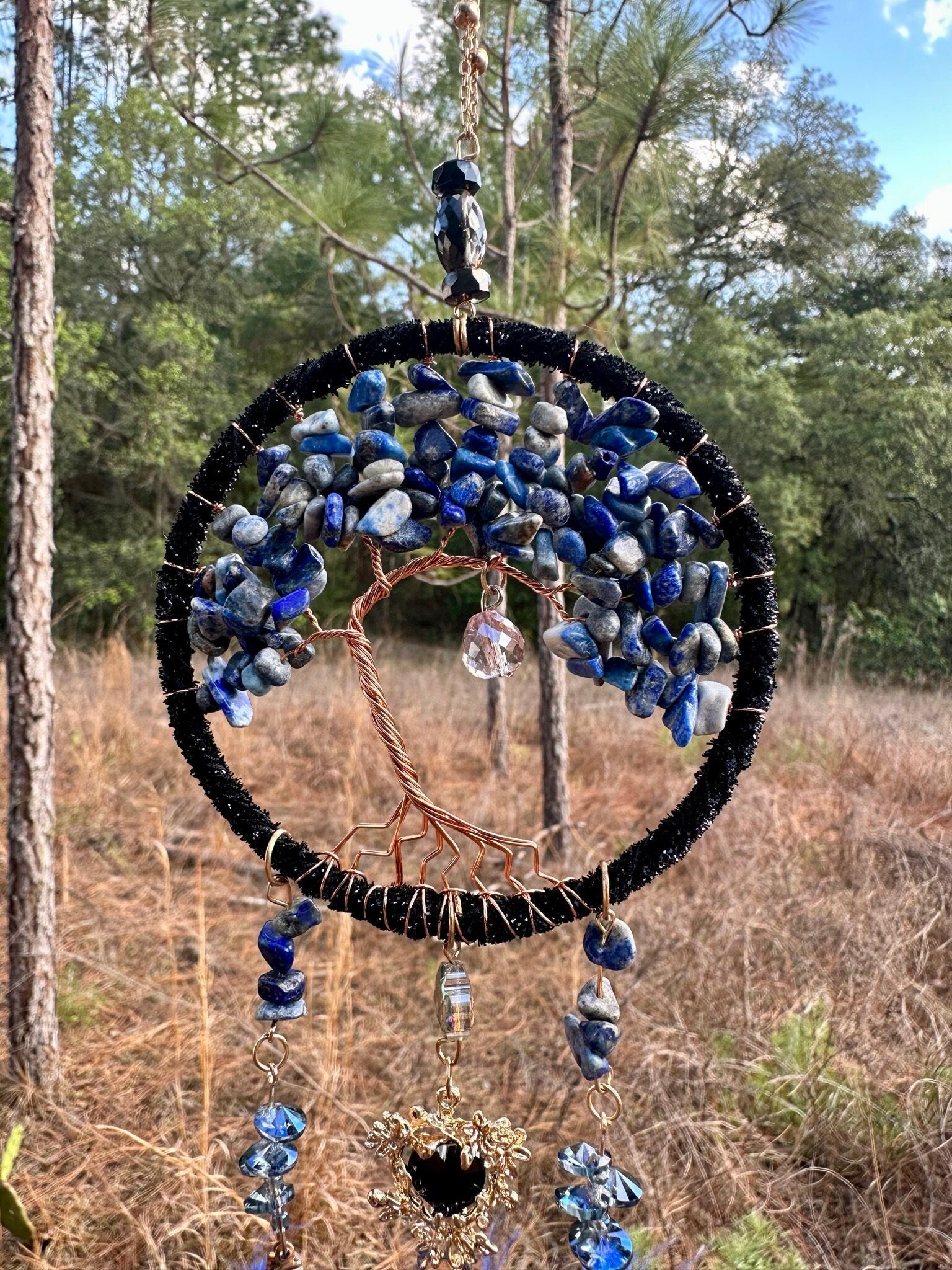Blue stone dreamcatcher with black rim, dangling beads, and black heart charm