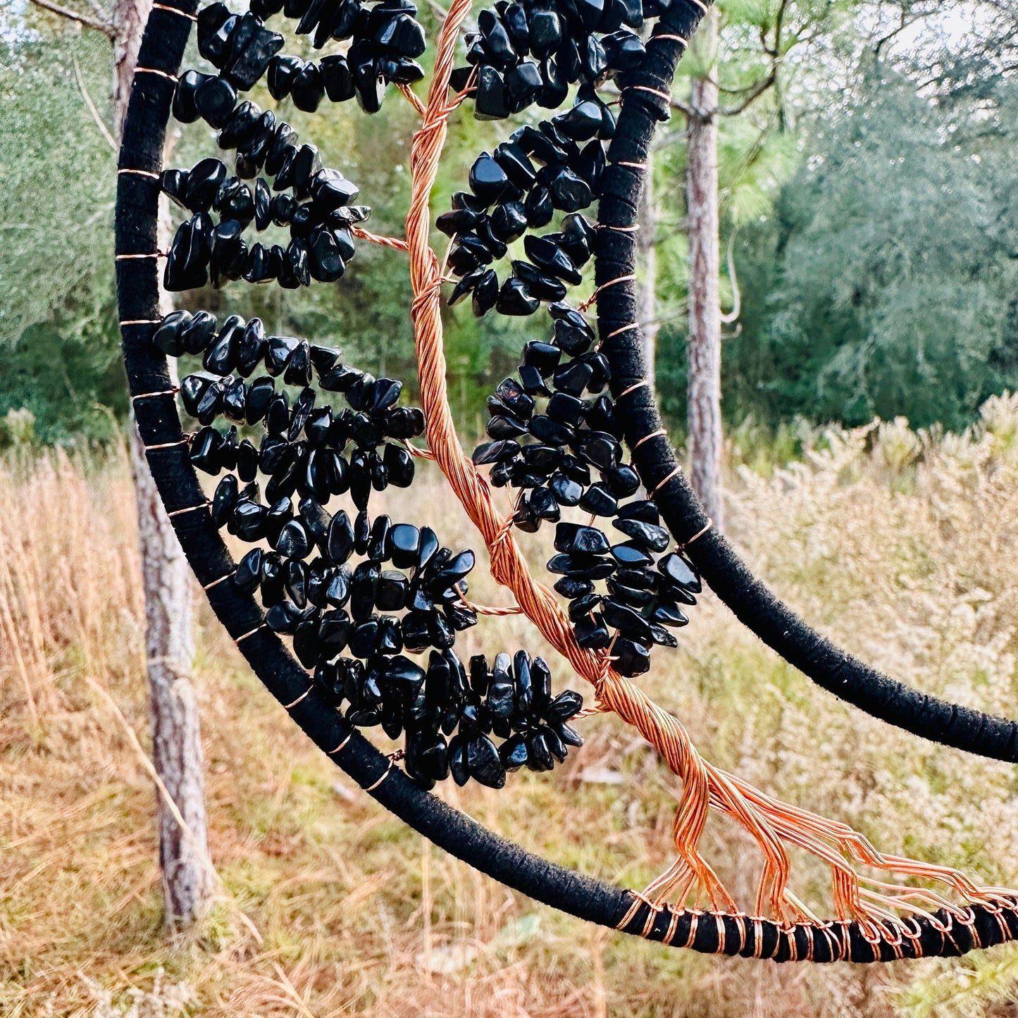 Close-up crescent dream catcher with black obsidian bead fringe and copper wire accents