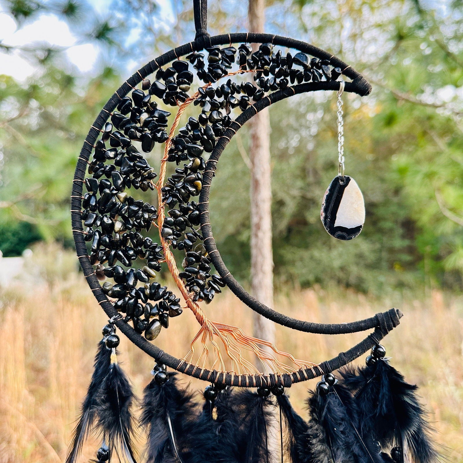 Crescent moon dream catcher wall hanging with black beads, feathers, and hanging stone charm