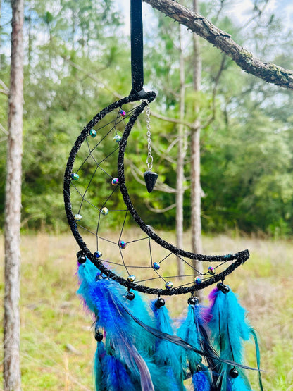 Crescent moon dream catcher with beaded net, hanging charm, and bright blue feathers