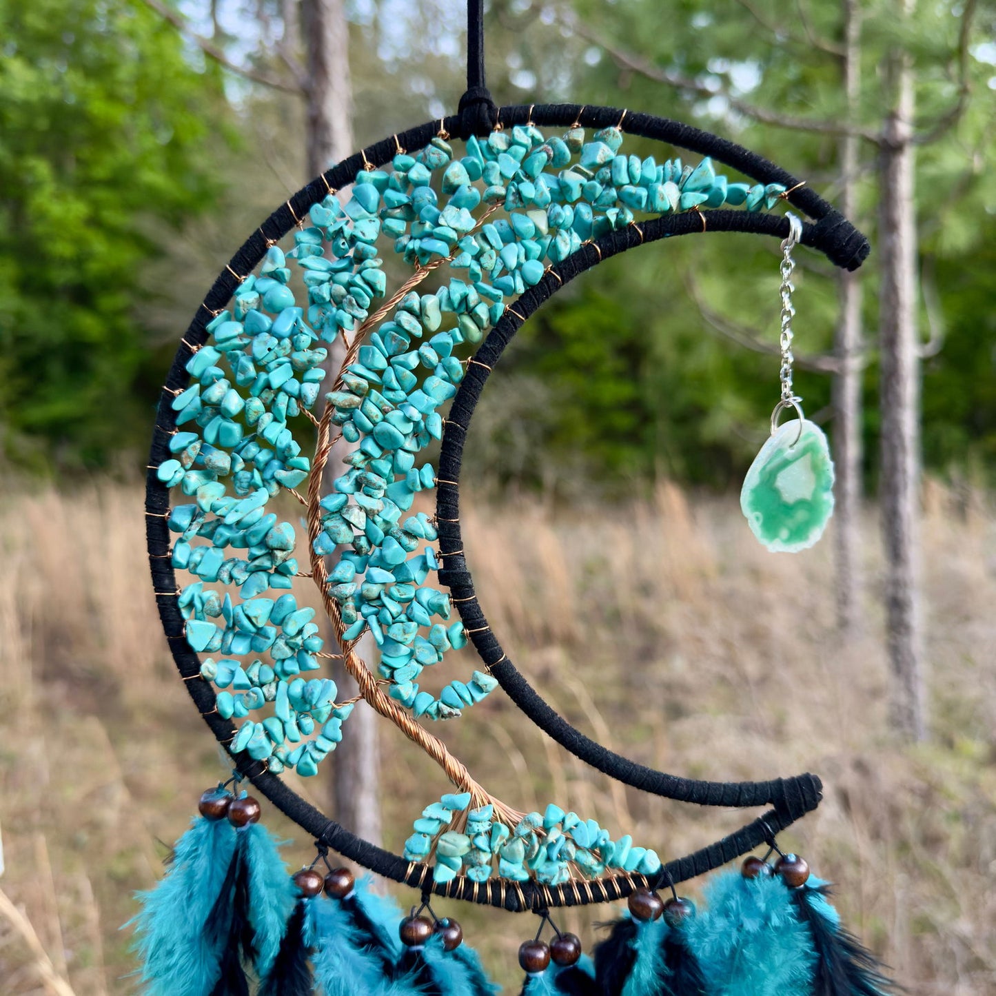 Crescent moon dream catcher with turquoise stones, blue fringe, and green charm