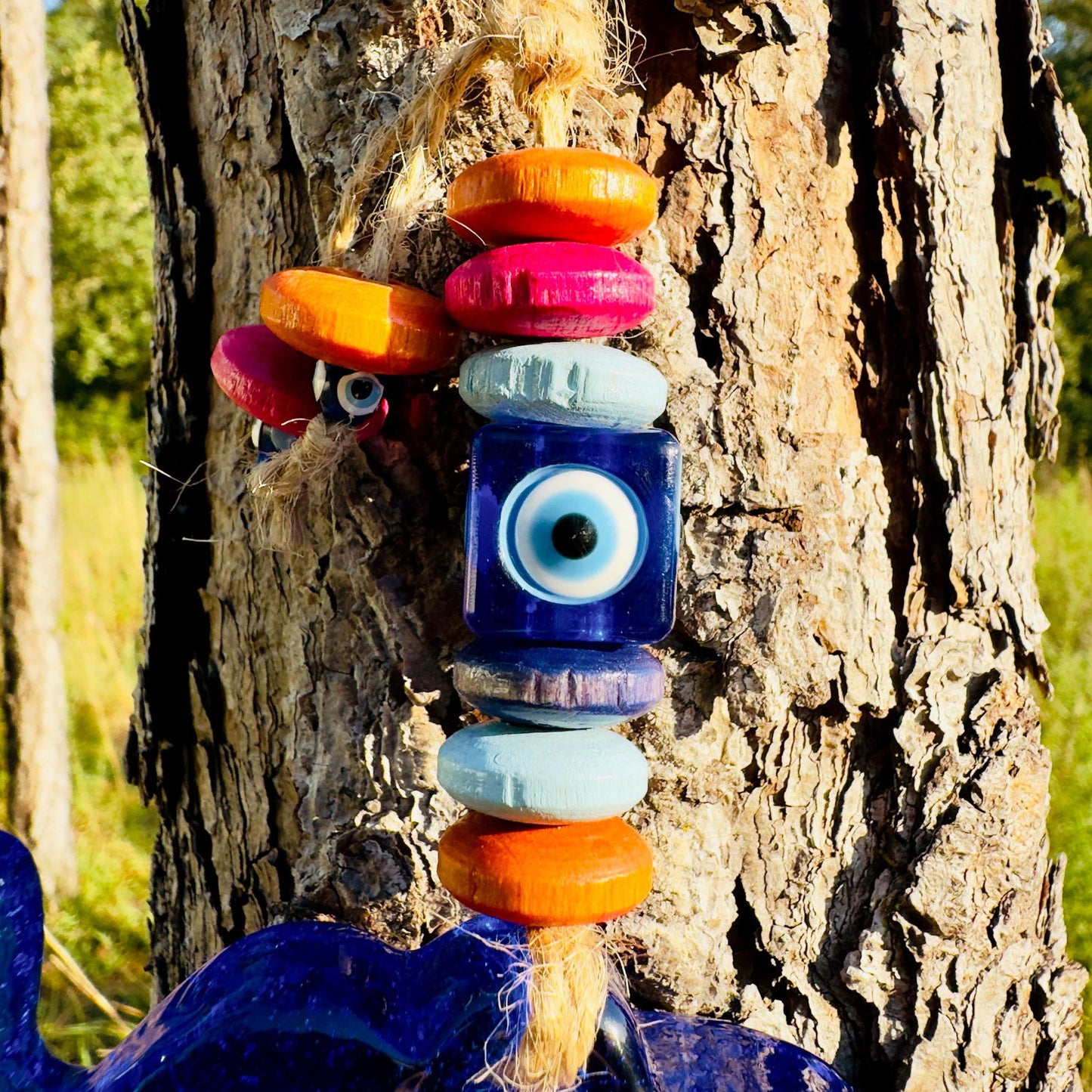 Mini elephant evil eye wall hanging with stacked orange, pink, and blue wooden beads