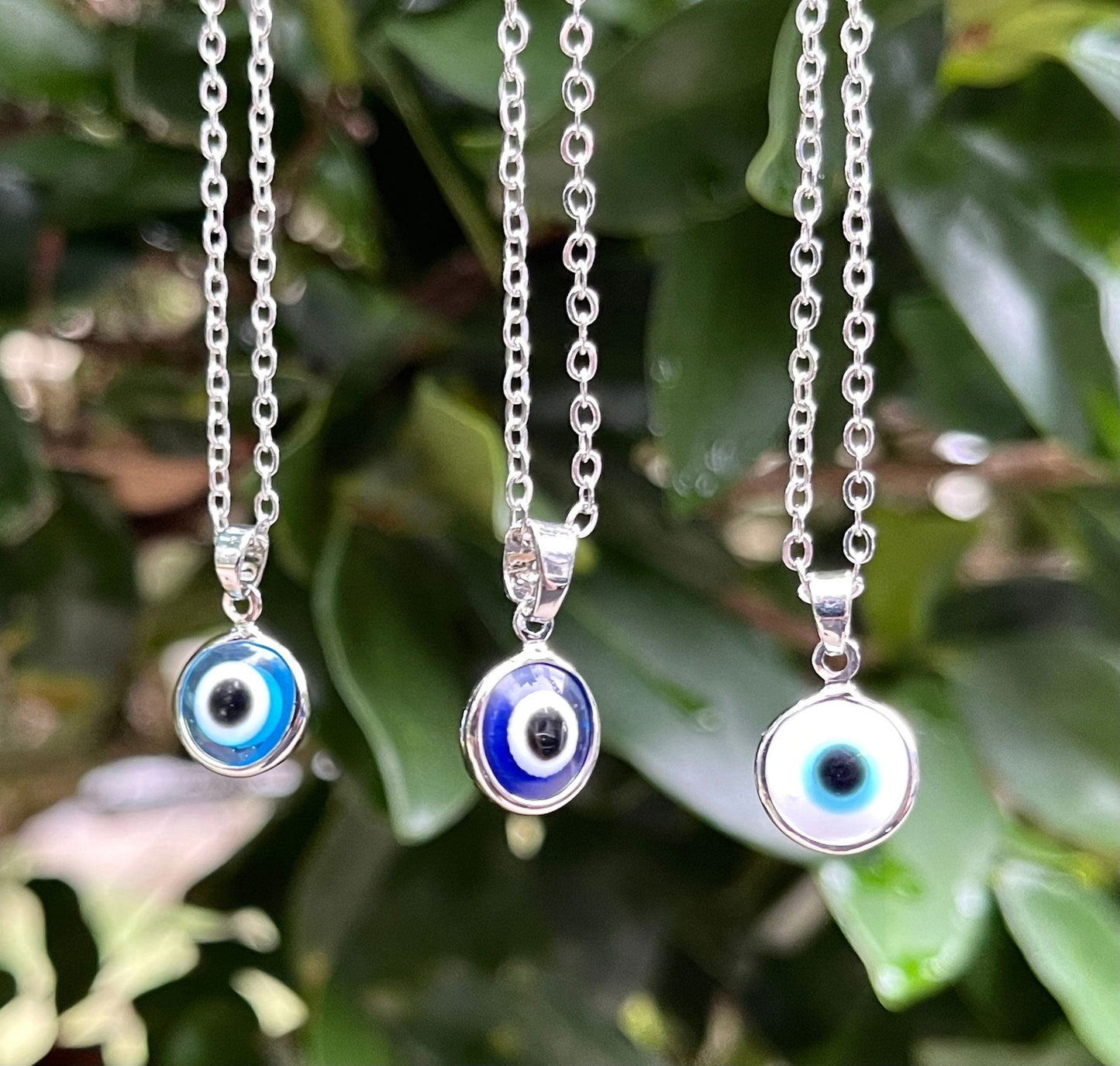 Stainless steel evil eye pendant necklace with small blue round charm on chain