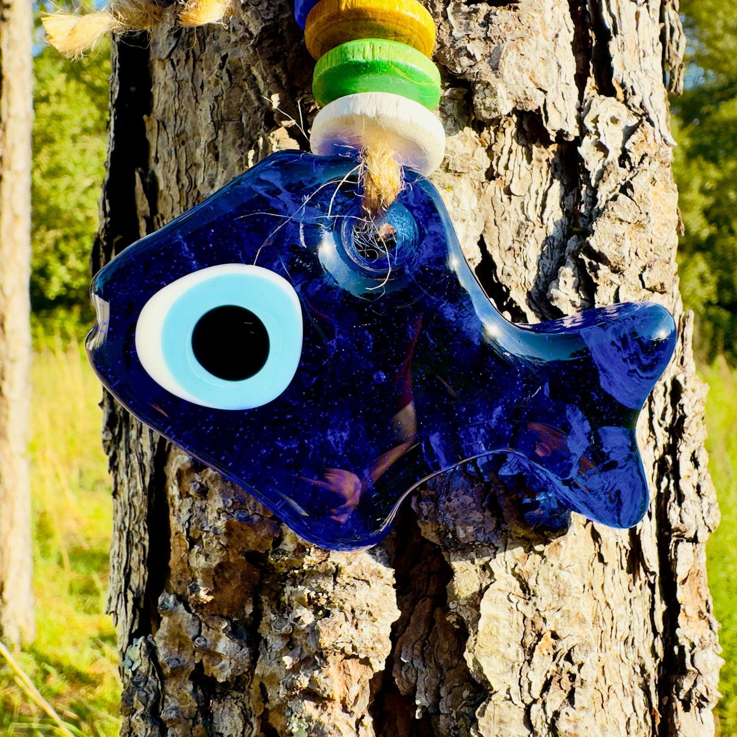 Blue fish evil eye wall hanging with large white eye and stacked colorful wood beads
