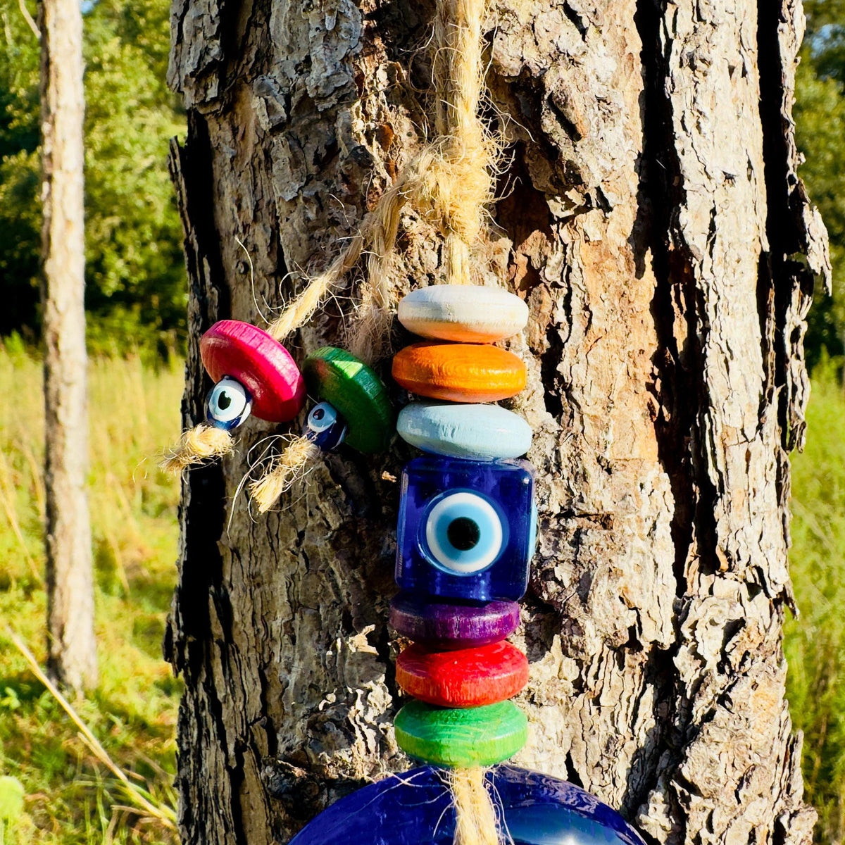 Colorful bead evil eye wall hanging with small charms on twine