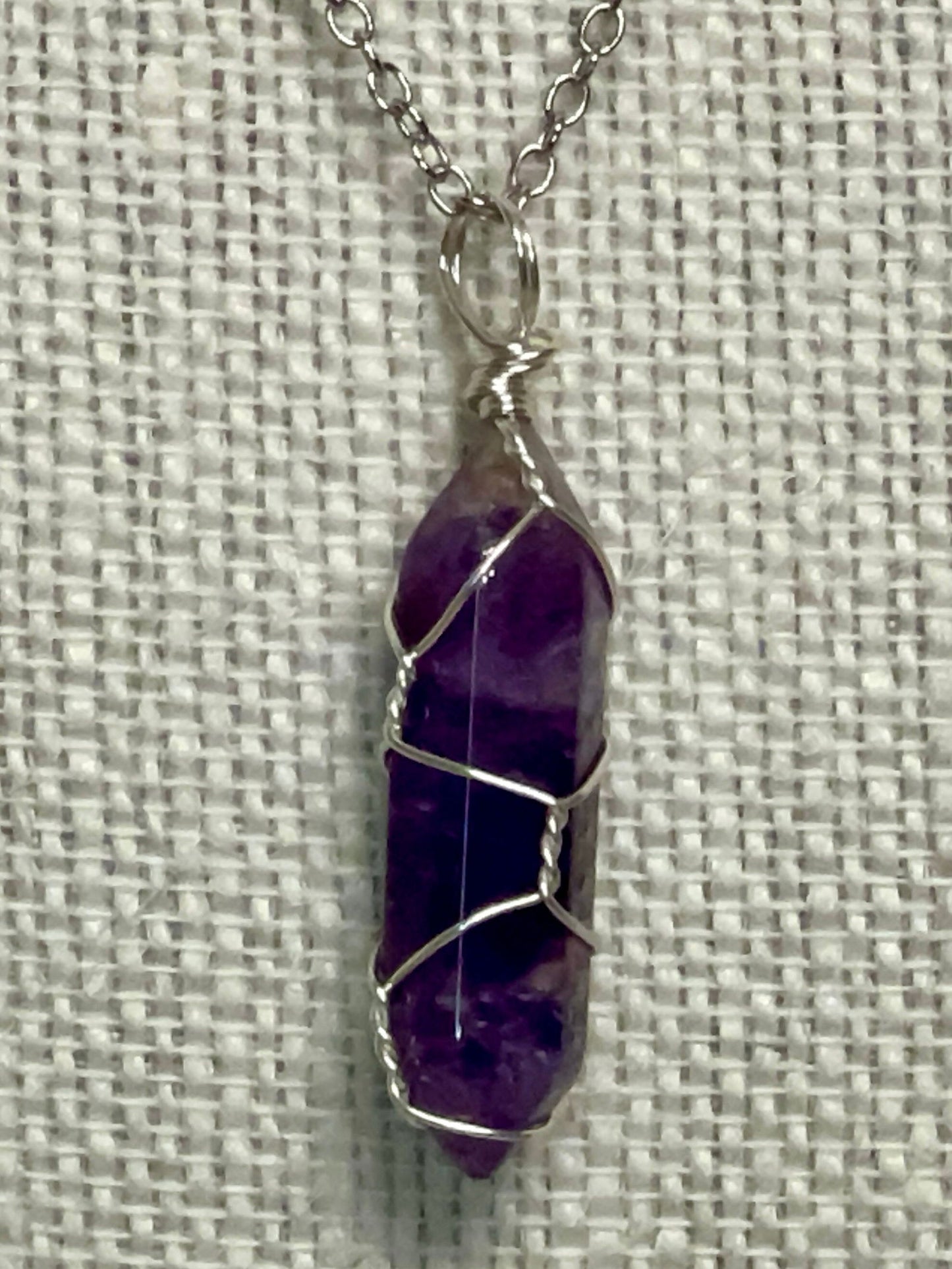 Silver wire-wrapped gemstone necklace with purple amethyst-style crystal pendant
