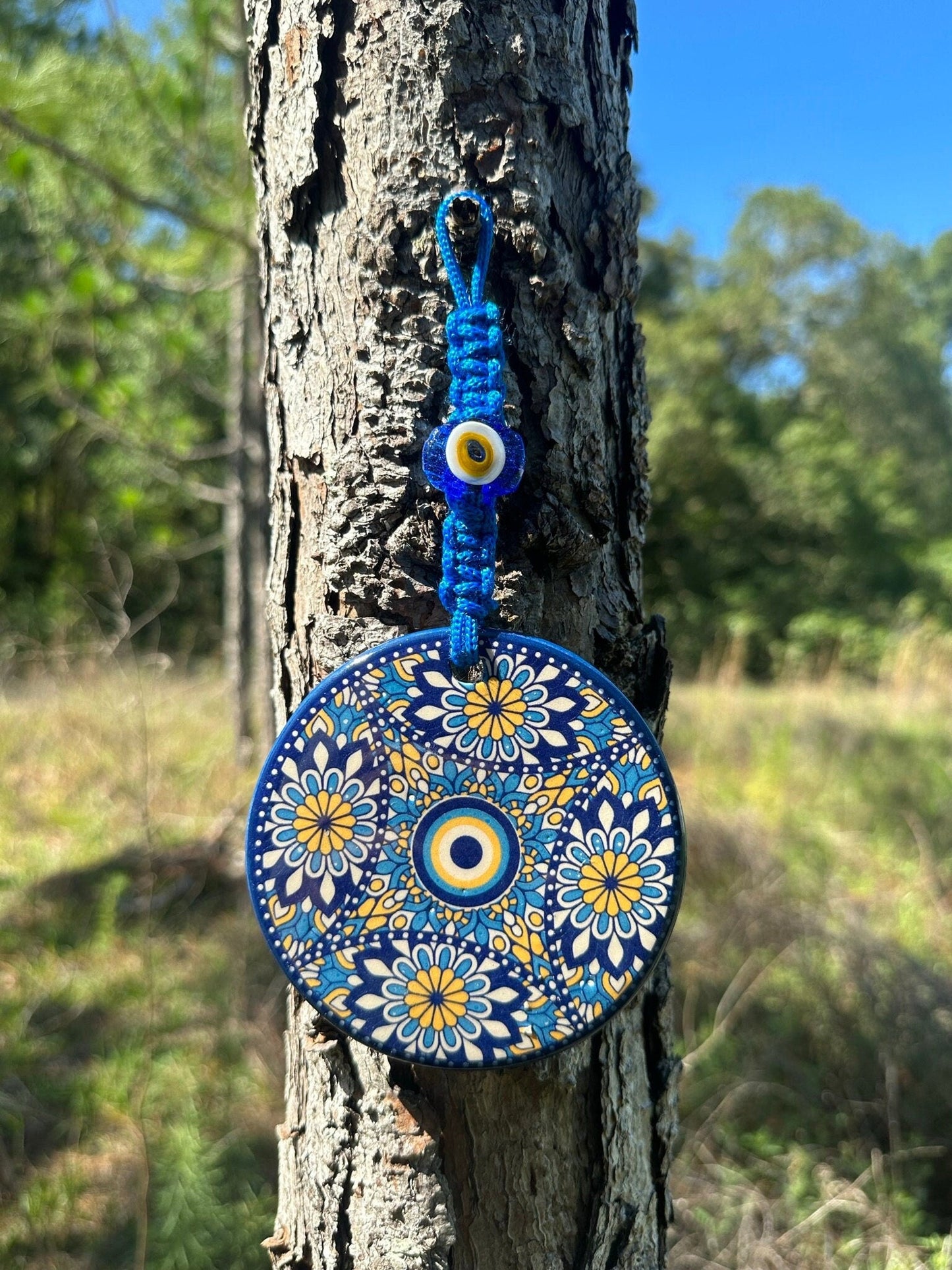 Blue ceramic evil eye wall hanging with floral mandala circular design and hanging loop