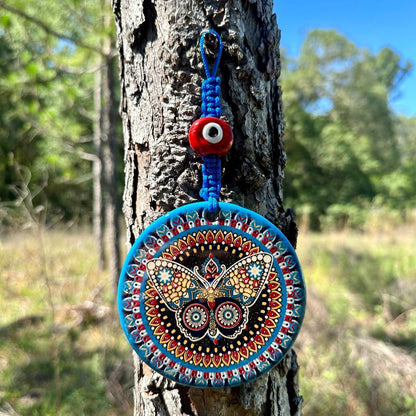 Blue ceramic evil eye wall hanging with round mandala, red-and-white bead charm