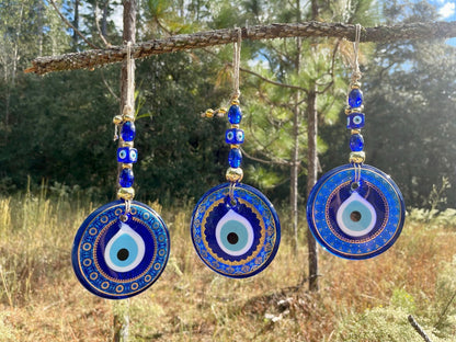 Set of three blue evil eye wall hangings with round pendants and bead tassels