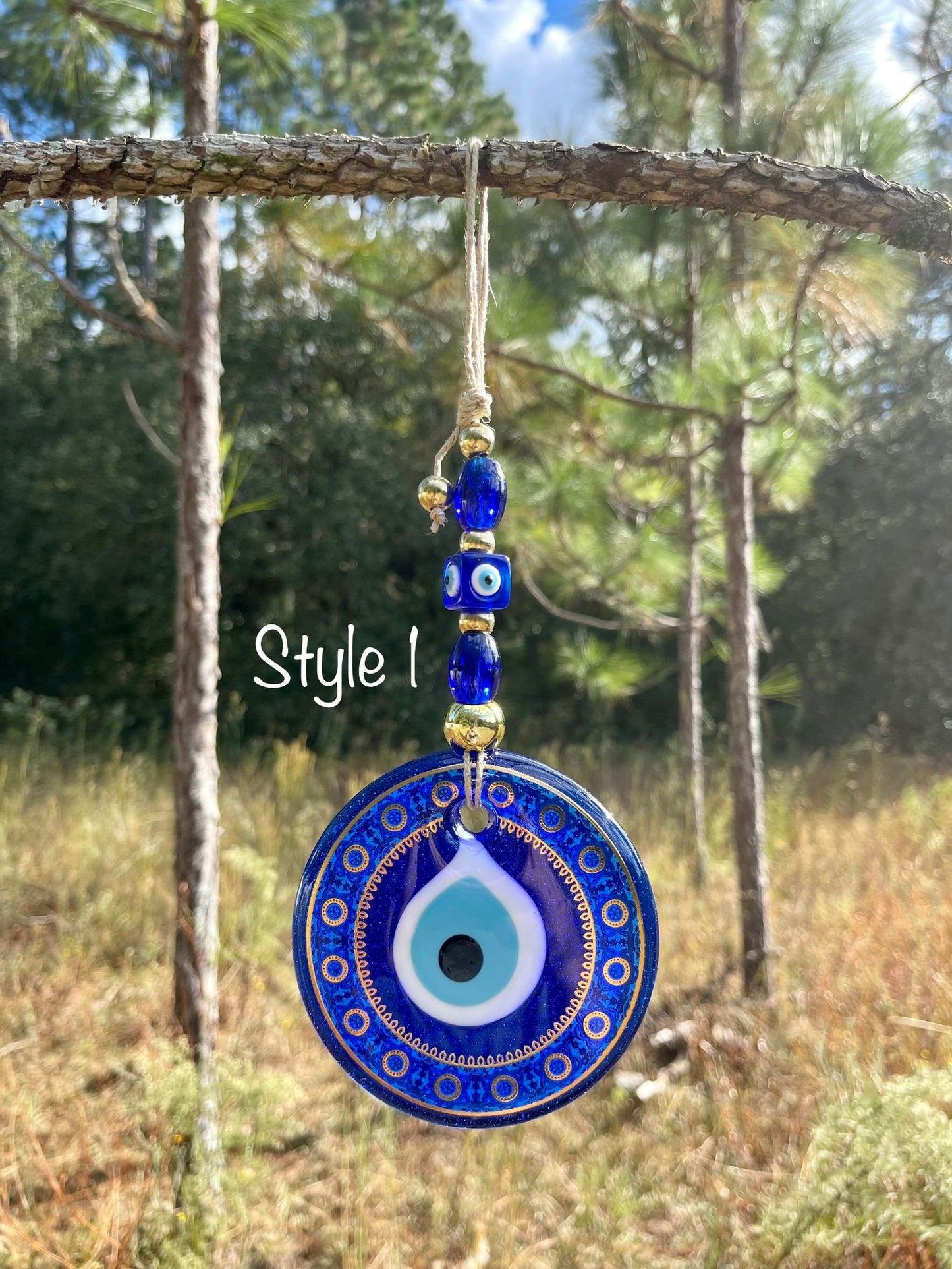 Blue evil eye wall hanging featuring a single round ornate pendant with bead links