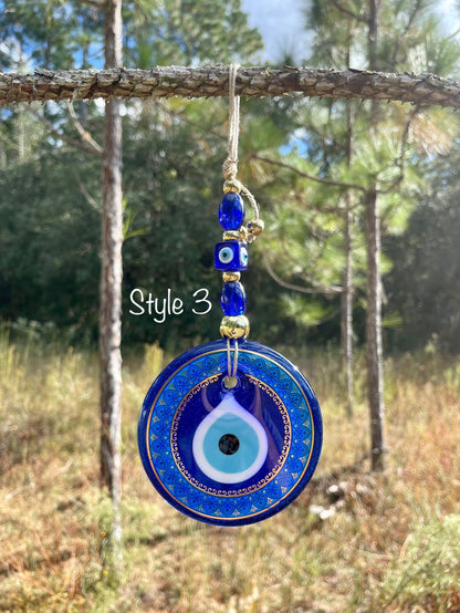 Blue evil eye wall hanging with one large round pendant and dangling blue bead charm